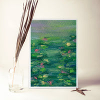 Monet's Lilies art print propped beside a glass vase of dried palm leaves (mock-up)